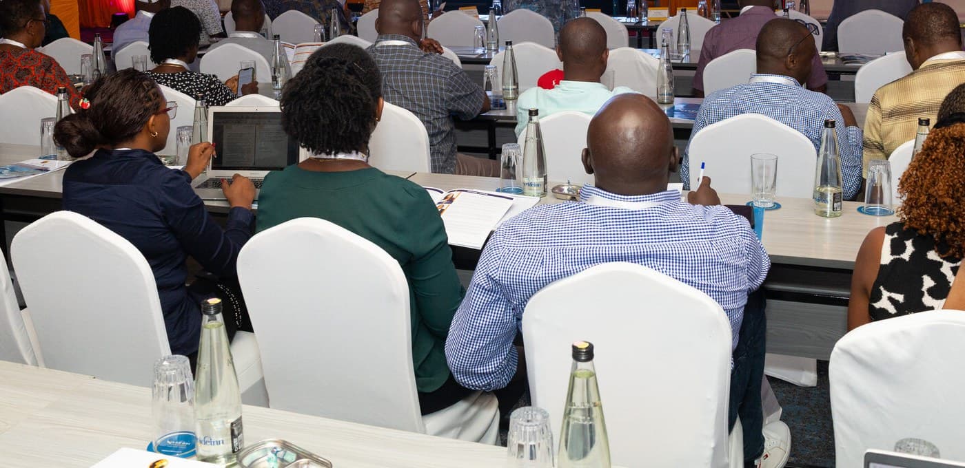 Delegates taking notes during a conference session